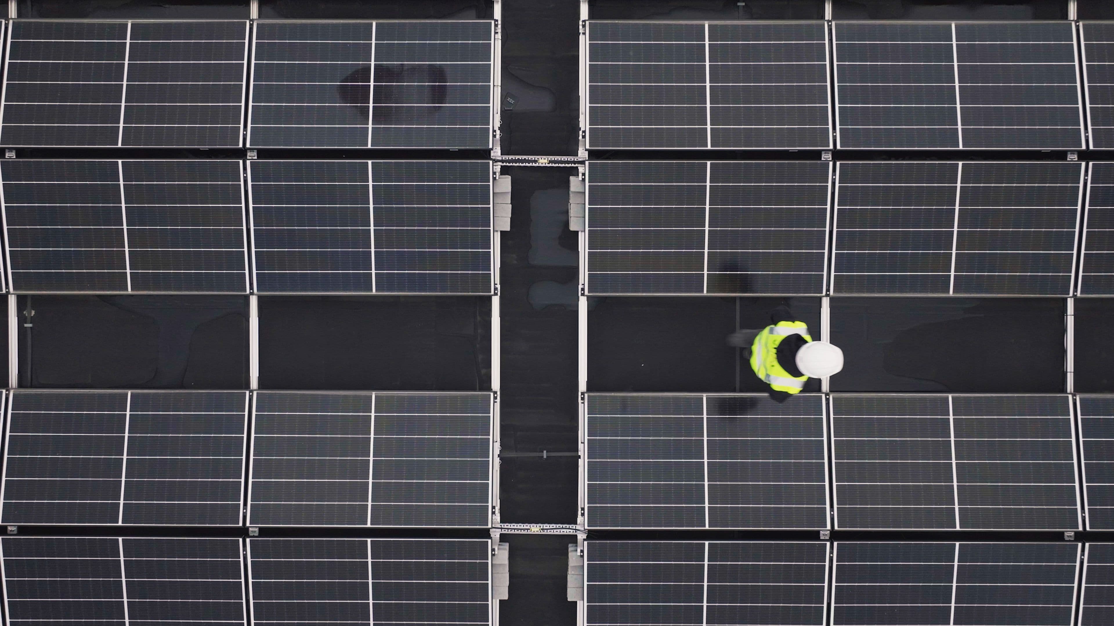 Engineer working among solar panels on a commercial rooftop